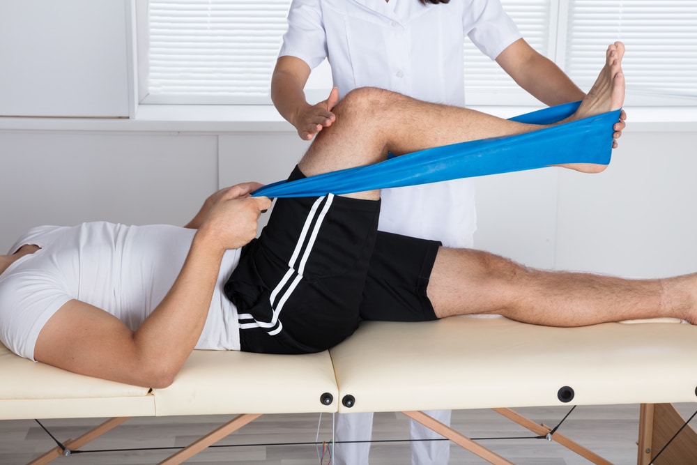 Osteopath treating patient with sports band