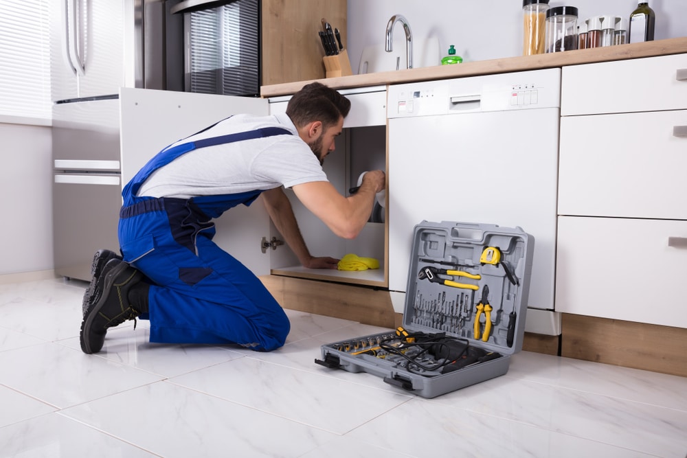 Plumber working kneeling on floor