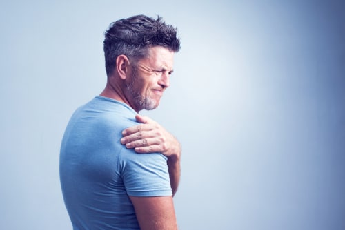 Man holding shoulder in pain