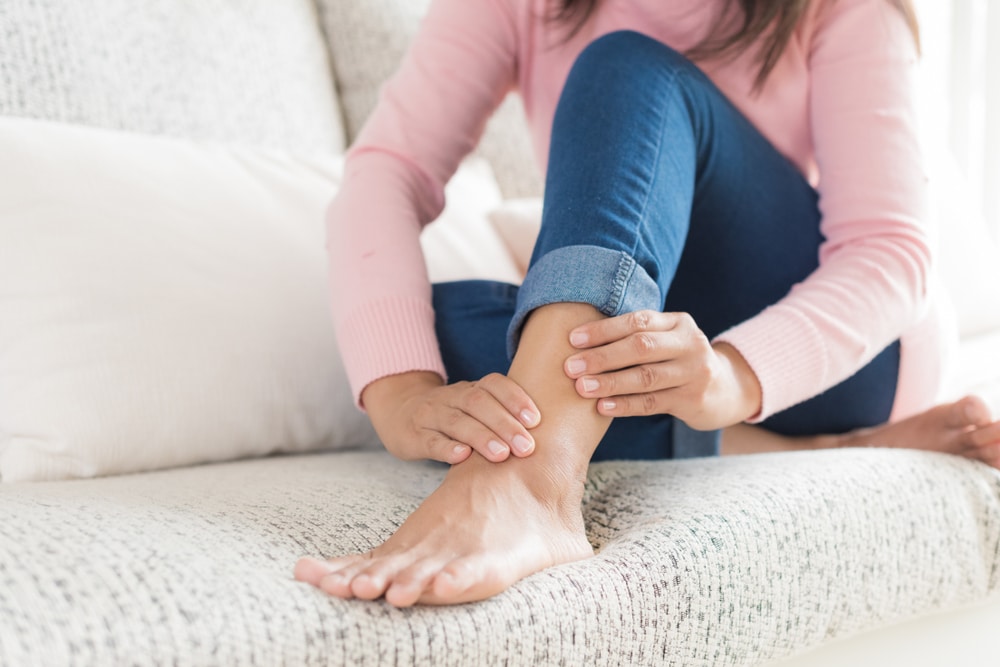 Woman holding ankle in pain