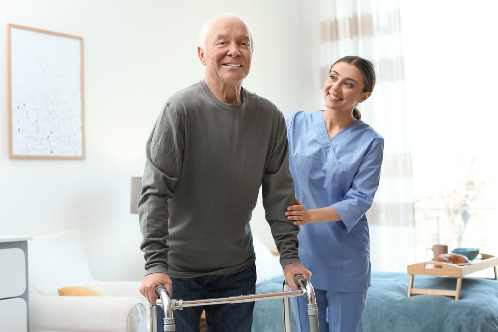 Osteopath helping man with walking frame