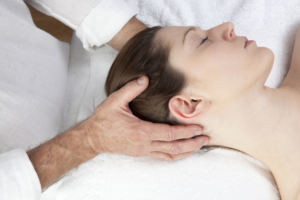 Osteopath treating woman's neck