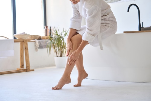 Woman with calf pain holding leg