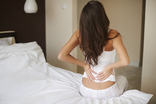 Woman holding her lower back in pain