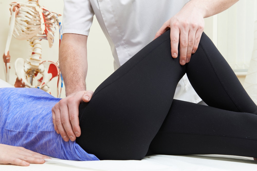 Osteopath treating patient for hip pain