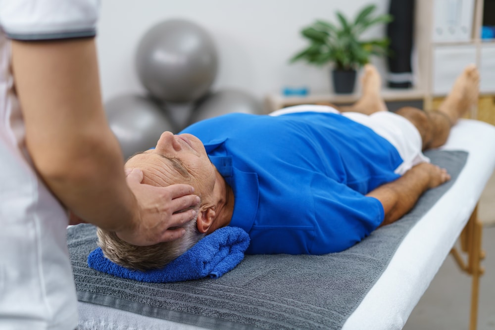 Osteopath treating elderly male patient