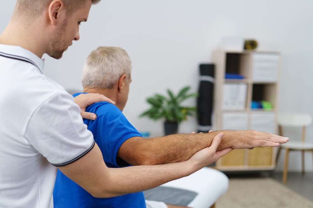 Osteopath treating elderly male patient